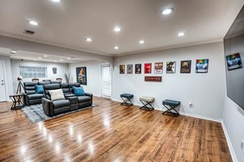 A living room with a couch and a wall filled with paintings